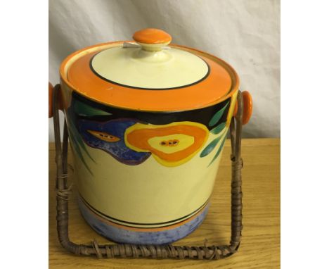 A Clarice Cliff biscuit jar and cover with a wicker-bound swing handle, from the Fantasque range. On base "Hand-painted Fanta