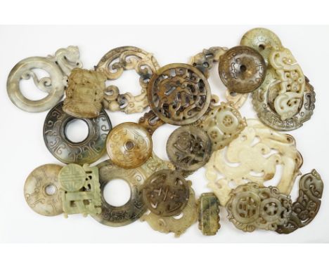 A collection of twenty three oriental carved jade and stone amulets of traditional form.
