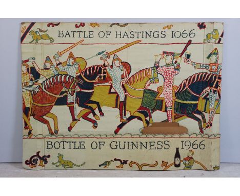 Vintage Guinness advertising board printed with the Bayeux tapestry holding Guinness glasses, marked 'Bottle of Guinness 1966