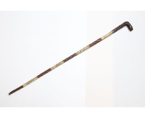 19th century shark vertebrae walking stick with carved wood sections and carved fish head handle