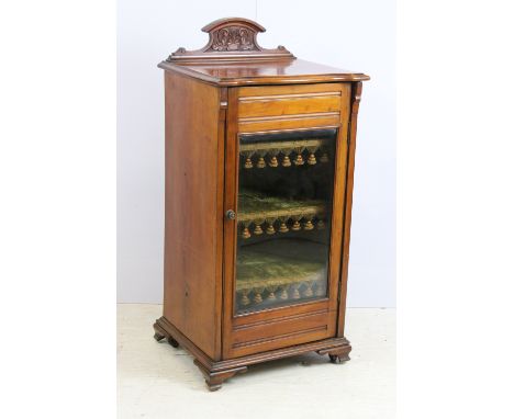 Edwardian mahogany music / drinks cabinet, with carved pediment above single glazed door, three velvet lined and fringed shel