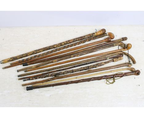 Collection of assorted walking sticks and canes to include bamboo examples with root ball handles (one carved), stick with ca