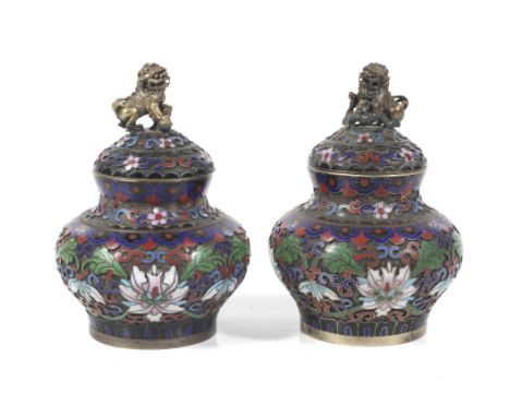 A pair of Chinese champleve and cloisonne enamel lidded vessels. Each finial in the form of a fo dog, one with a young animal