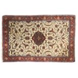 A cream ground rug with blue and red decoration.