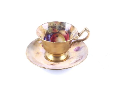 A Royal Worcester teacup and saucer. The teacup dated 1926 with a git exterior and an inteior handpainted with apples and gra