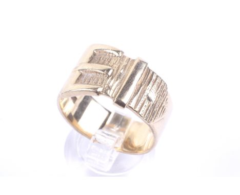 A vintage 9ct gold 'buckle' ring. The textured buckle on a plain broad flat-section  shank with hallmarks for Birmingham 1973