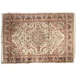 A cream ground rug with red decoration.