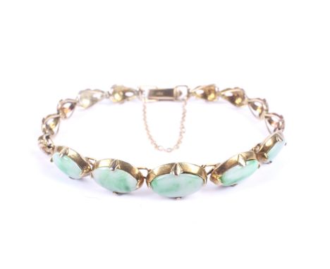An Oriental jadeite panel bracelet. The front designed as five slightly graduated oval mottled-jadeite panels, all claw set b