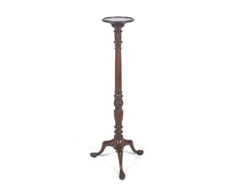 A 19th century mahogany plant stand or torchere. The circular dish top on a part turned reeded and leaf carved column, with a