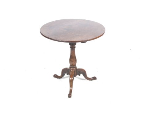 A 19th century mahogany tripod table. The circular tilt-top on turned column, raised on carved cabriole legs with bun feet, H