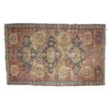 A red ground rug with blue central medallions. A blue stylized wave boarder. L212cm x W130cm.