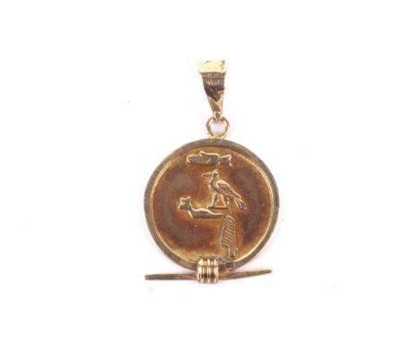 A vintage Egyptian yellow metal pendant. In the form of a disc with hieroglyphs and a bar, the bale with indistinct marks, 2.