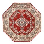 Two octagonal red ground wool rugs.