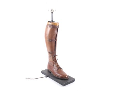 A novelty table lamp formed from a vintage leather riding boot. The light drilled through the boot tree, the boot fixed to a 