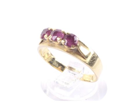 A vintage ruby three stone ring. The round mixed-cut stones approx. 3.6mm diameter, each claw set on a flat-section band stam