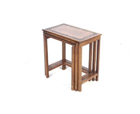 A vintage oak nest of three tables and a carved stool. The tables of rectangular form with square supports and casters, large