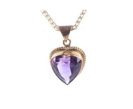 A vintage 9ct gold and heart-shaped amethyst single stone pendant and chain. The deep-purple amethyst rub-over set within a r