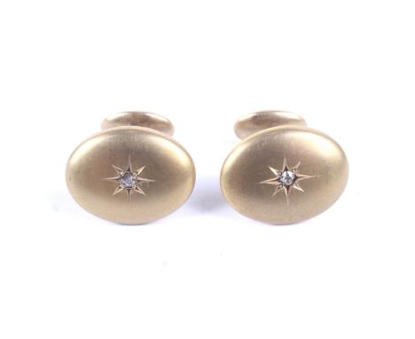 A pair of vintage gold and diamond oval cufflinks. Each link with an oval panel star-gypsy set at the centre with a small old