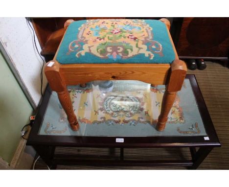 A glass top coffee table with tapestry decoration with a tapestry top pine stool