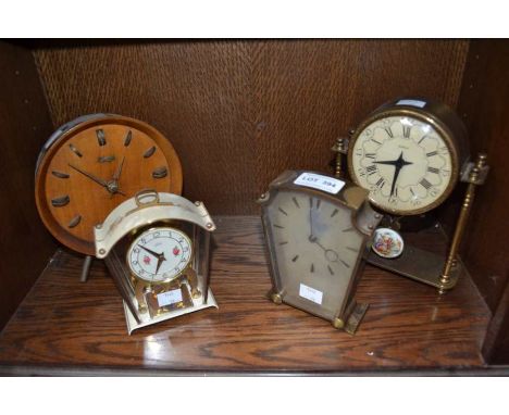 A brass mantle clock with three other similar vintage examples