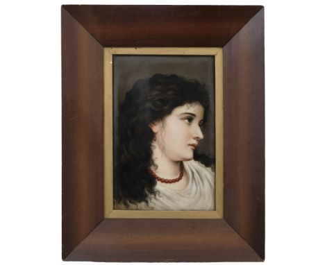 A late 19th Century porcelain portrait plaque of a young European lady in profile, wearing a bead necklace, indistinct pencil