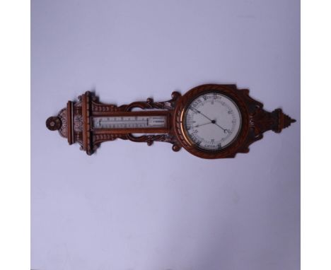 A late Victorian aneroid barometer, circa 1890, carved oak case with scrollwork, thermometer over the principal dial, height 