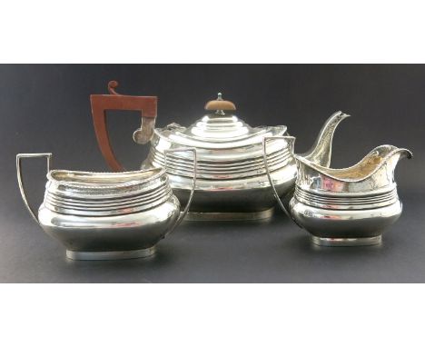 A George V silver three piece tea set, S W Smith and Co., Birmingham 1923, squat and reed boat form with gadrooned borders, t