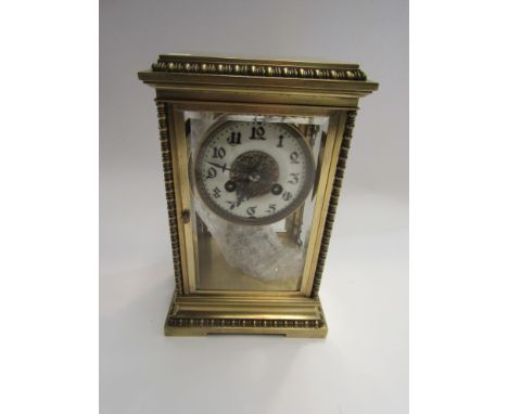 A brass four bevelled glass mantel clock with numerated chapter ring 