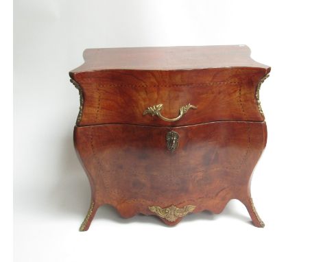 An early to mid 20th Century walnut cased decanter set, the commode shaped box opening to reveal lift-out tray, decanter and 