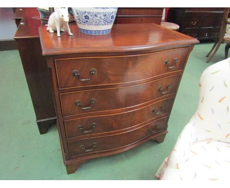 A Georgian style crossbanded flame mahogany serpentine front chest of four drawers, the reeded canted corners over bracket fe