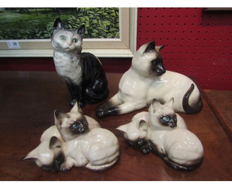 Three Royal Doulton Siamese cats and a Beswick black &amp; white example