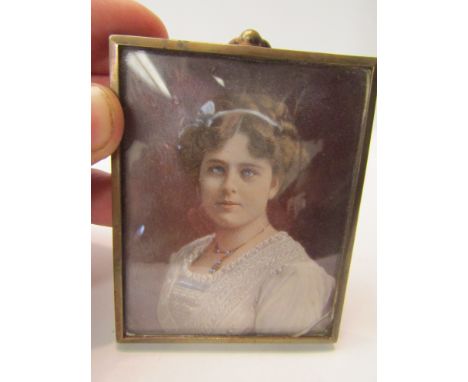 A miniature painted portrait of lady, monogrammed AB and dated 1912, in brass surround