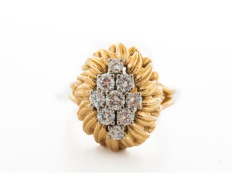 A GOLD AND DIAMOND NINE STONE CLUSTER RINGClaw set with round brilliant cut diamonds in a lozenge shaped floral design, betwe
