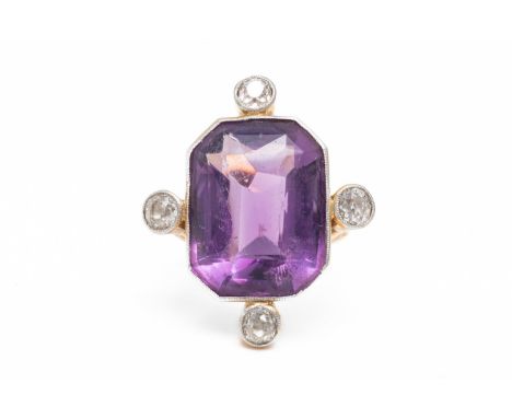 AN AMETHYST AND DIAMOND RINGWith a central bezel set emerald cut amethyst measuring 17.7mm x 13.4mm, compass set with four ol