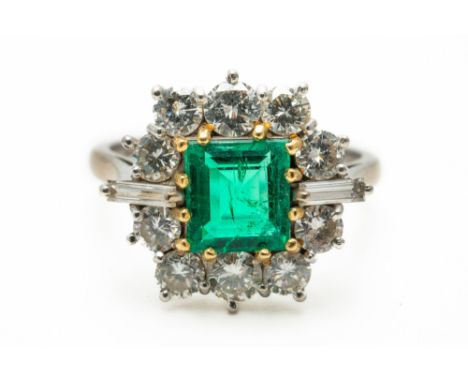 AN EMERALD AND DIAMOND CLUSTER RING (2)The central claw set emerald weighing an estimated 1.13 carats, surrounded by ten roun