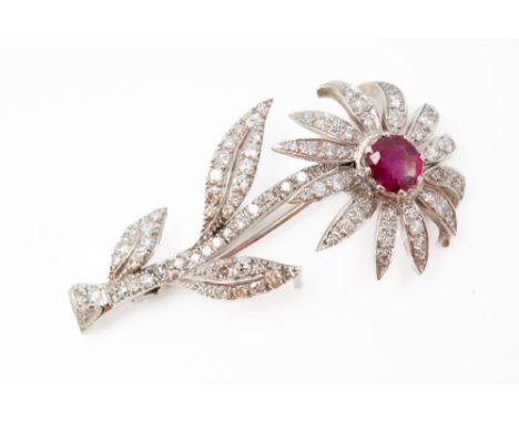 A RUBY AND DIAMOND BROOCHDesigned as a flower spray, claw set with the oval cut ruby to the flowerhead centre and otherwise m