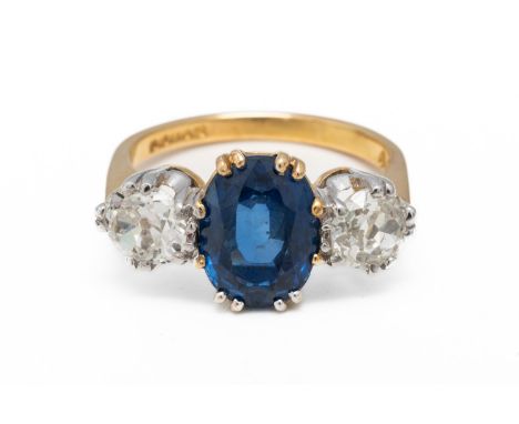 A SAPPHIRE AND DIAMOND THREE STONE RING (2)With a central oval cut sapphire measuring 9.69mm x 7.11mm x 4.89mm, claw set and 