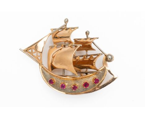 AN ITALIAN GOLD AND RUBY SAILING SHIP BROOCH (2)The five round cut rubies claw set to the textured white gold hull, with yell