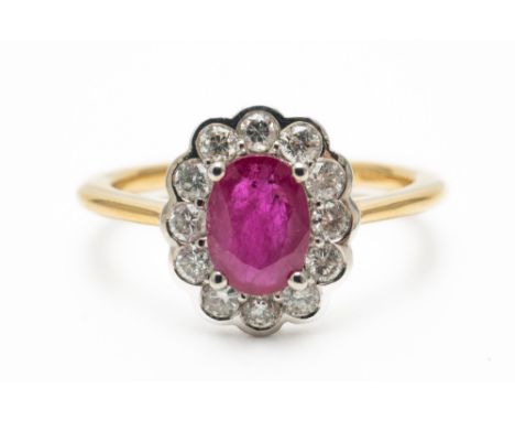 A RUBY AND DIAMOND FLORAL CLUSTER RINGWith a central oval cut ruby measuring 7mm x 5.2mm, claw set and surrounded by round br