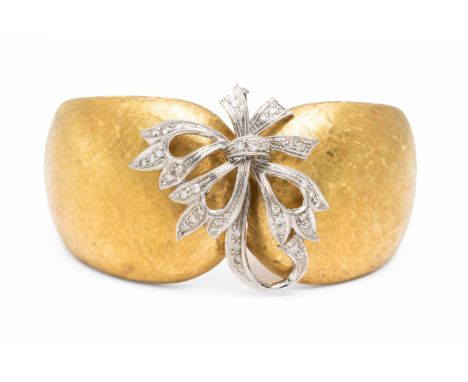 AN ITALIAN GOLD AND DIAMOND BANGLE (2)The brushed surface with graduating hinged edges, internal diameter 57.6mm x 43.9mm, st