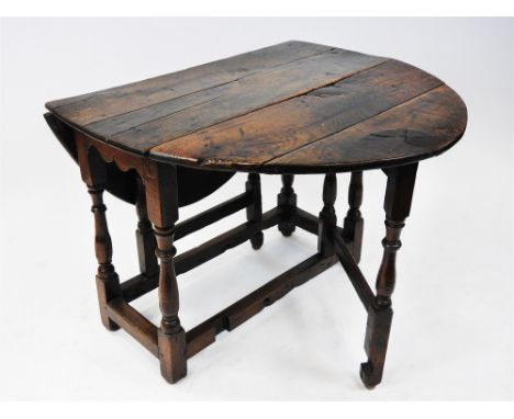 An oak single gate leg action table, basically 18th century, the oval six plank top above cut bracket ends and raised on six 