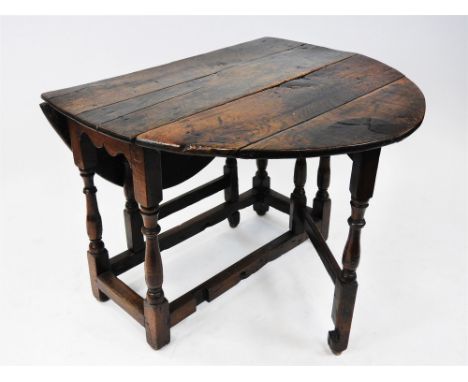 An oak single gate leg action table, basically 18th century, the oval six plank top above cut bracket ends and raised on six 