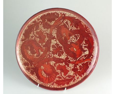 Maw and Co ruby lustre charger circa 1885, decorated with stylised serpentine beasts in typical ruby lustre glaze against cre