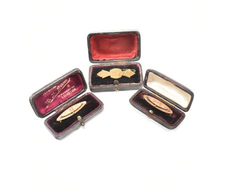 A collection of three antique gold plated and boxed brooch pins. The first pin having etched floral and scrolling design to C