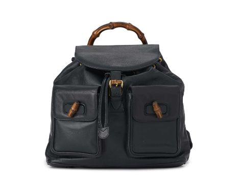 Gucci, a large Bamboo backpack, featuring a smooth navy blue leather exterior, curved bamboo top handle, two front patch pock