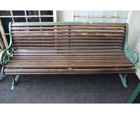 A VICTORIAN GARDEN BENCH WITH CAST IRON FORM ENDS AND WOOD SLATTED SEAT.