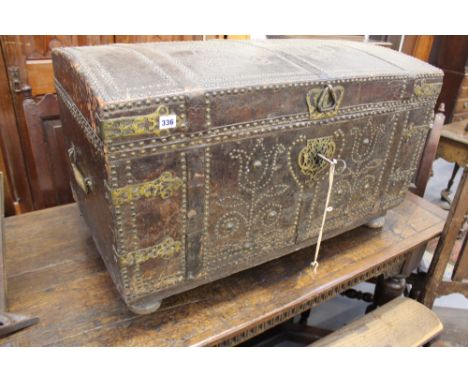 AN EARLY 18TH CENTURY. LEATHER HIDE UPHOLSTERED DOME TOP TRAVELLING CHEST/CASKET WITH ELABORATE BRASS STUD WORK DECORATION IN