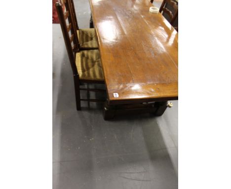 A BESPOKE OAK REFECTORY TABLE ON TURNED LEGS WITH H STRETCHER TOGETHER WITH A SET OF EIGHT RUSH SEAT LADDER BACK DINING CHAIR