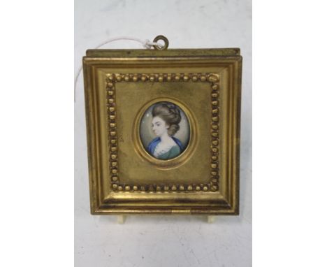 AN OVAL MINIATURE WATERCOLOUR PORTRAIT OF A GEORGIAN LADY WEARING A GREEN DRESS IN MOULDED GILT FRAME.