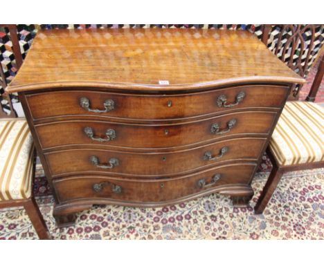 A GEORGIAN MAHOGANY SERPENTINE FRONT FOUR DRAWER GENTLEMAN'S DRESSING CHEST IN THE MANNER OF THOMAS CHIPPENDALE